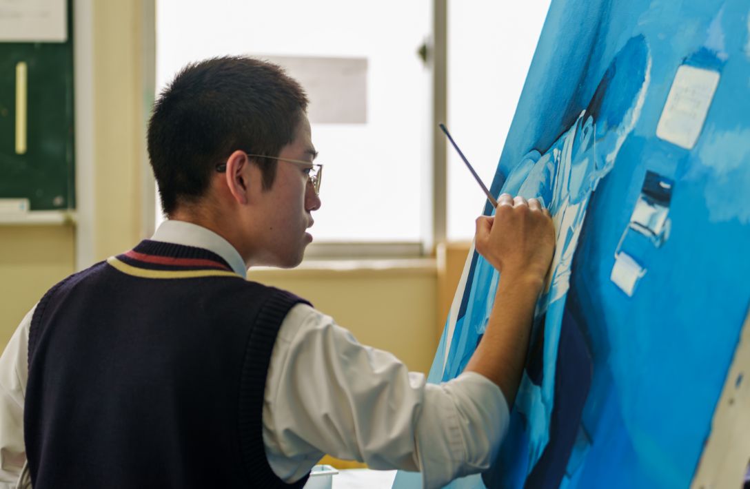 キャンパスに絵を描く生徒