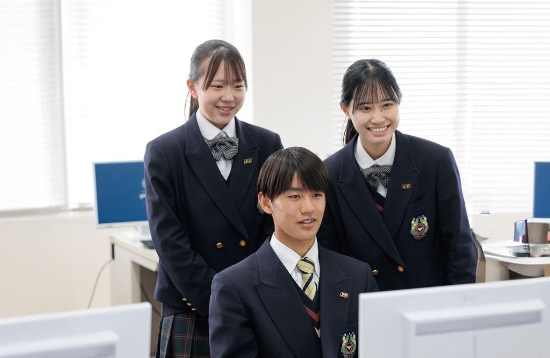 パソコンの画面を見る三人の生徒